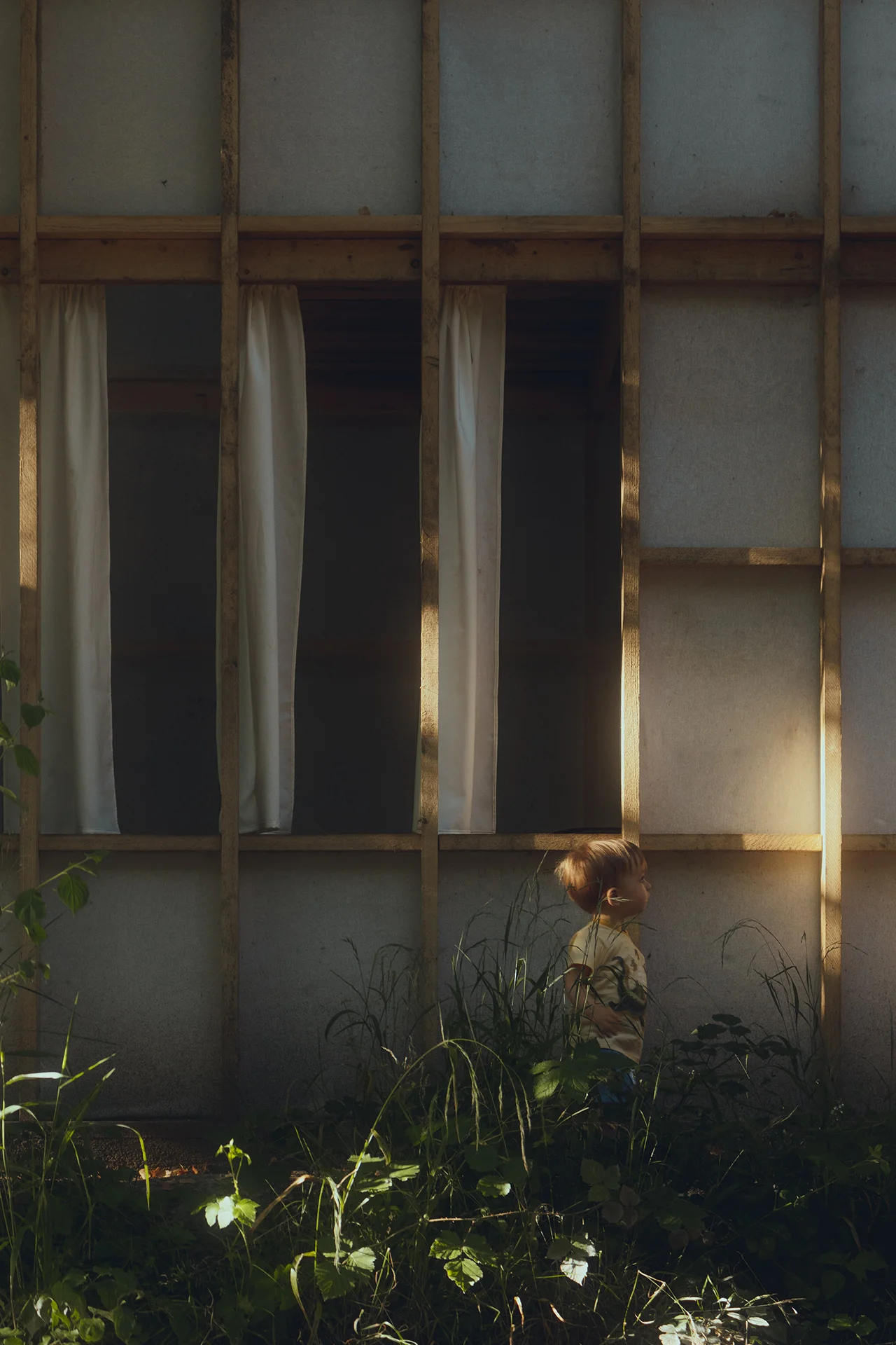 Zoom sur la façade en bois et en tissu, présence du soleil et passage d'un enfant